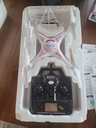 White quadcopter drone with controller in retail box