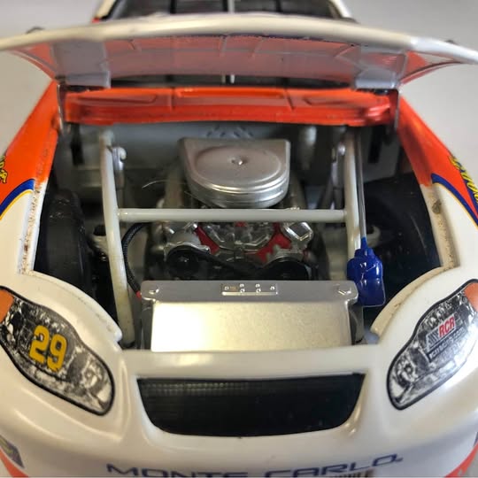 Orange and white #29 diecast race car with hood open, engine detail and front fascia