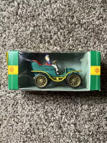 Vintage teal diecast model car in open display box, 1:43 scale