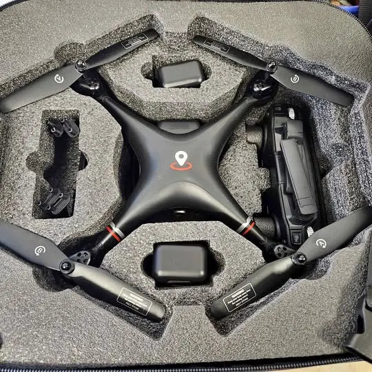 Black quadcopter drone with propellers in foam carrying case with batteries