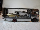 Diecast tow truck model with enclosed trailer, brown cab, exposed car inside.