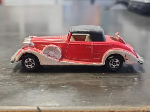 Red vintage diecast roadster car with black roof, 1/72 scale