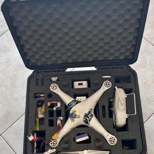 DJI Phantom quadcopter drone in protective case, white body, landing gear.