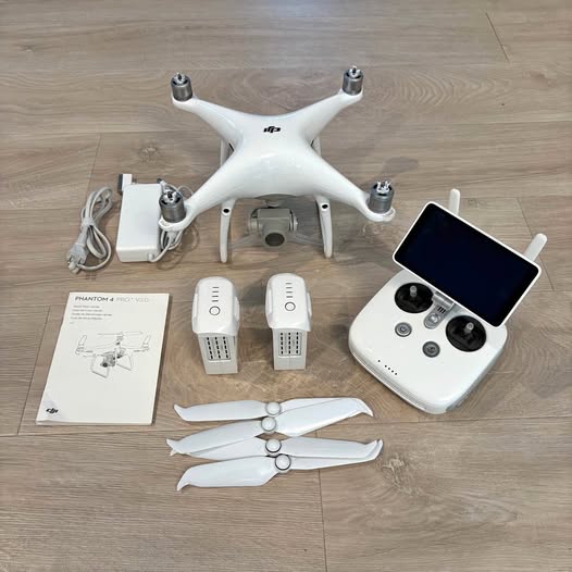 White quadcopter drone kit with remote controller, batteries, propellers and manual