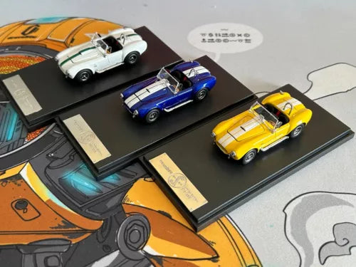 Diecast model cars with open engine hoods, blue, yellow, and white