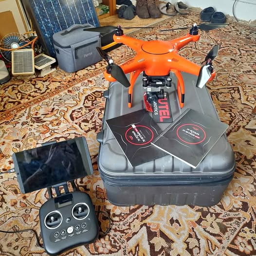Orange quadcopter drone with controller and carrying case