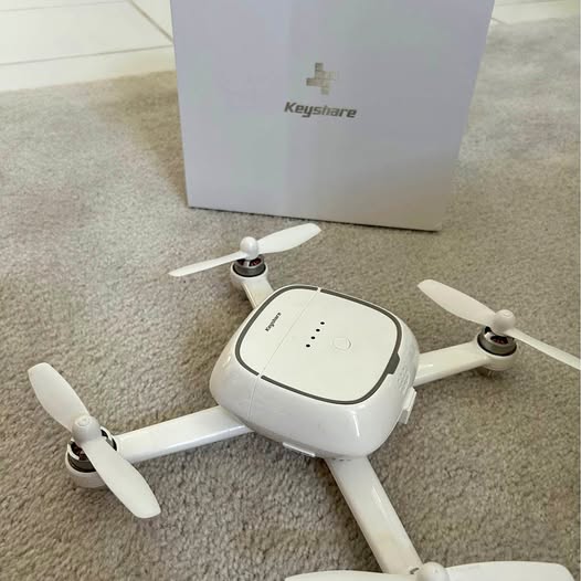 White quadcopter drone with four propellers and top control panel
