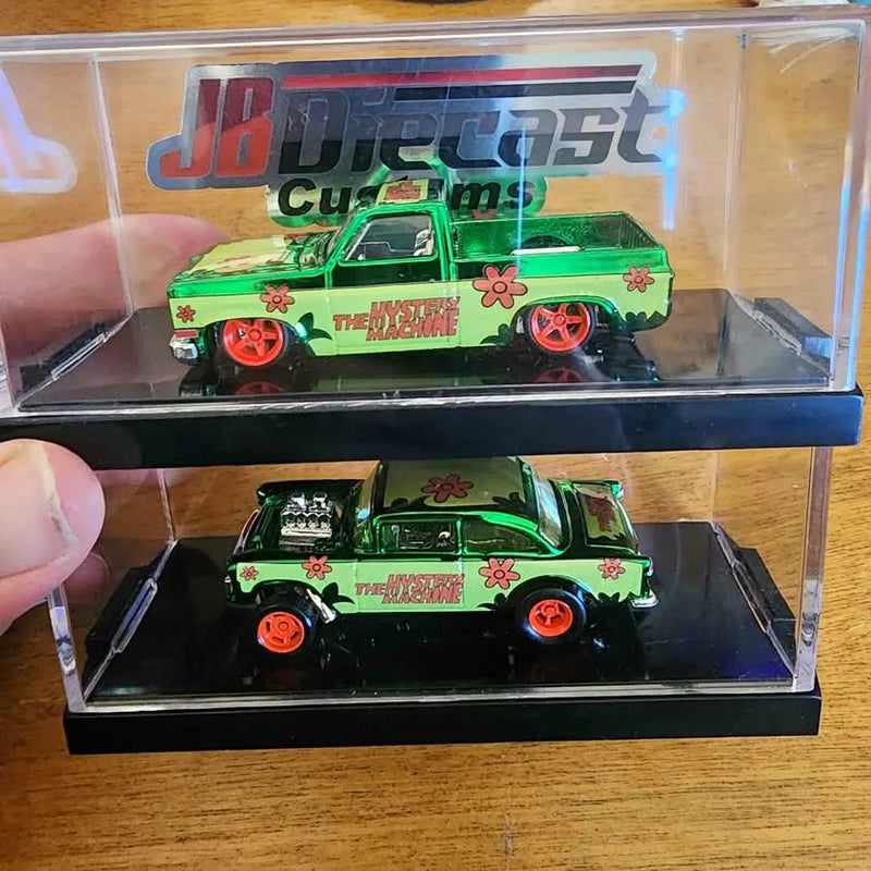 Green diecast model car in clear box, with flower decals and orange wheels