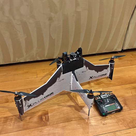 Quadcopter drone with gimbal, four prop arms, landing legs, and handheld controller