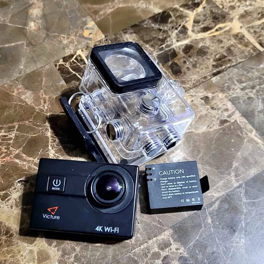 Underwater action camera with clear waterproof housing and black 4K lens module