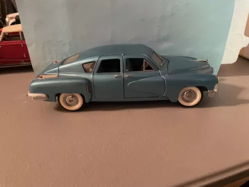 Blue vintage Tucker-style diecast car model with side view and chrome trim