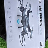 Silver-gray quadcopter drone with four rotors shown on retail box