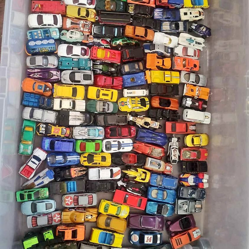 Diecast toy car lot with many small colorful cars stacked together