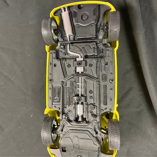 Yellow 1:18 diecast Beetle model car underside and suspension details
