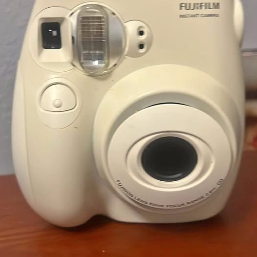 Fujifilm instant film camera, cream white front with lens and viewfinder