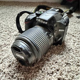 Nikon D3200 DSLR camera with attached lens, black