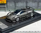Gray and black 1:64 scale diecast sports car model on black display base.
