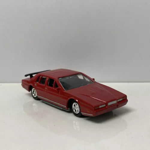 Red diecast Aston Martin Lagonda car model with black tires and chrome wheels