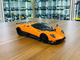 Orange 1/18 diecast sports car model with low front profile and black wheels