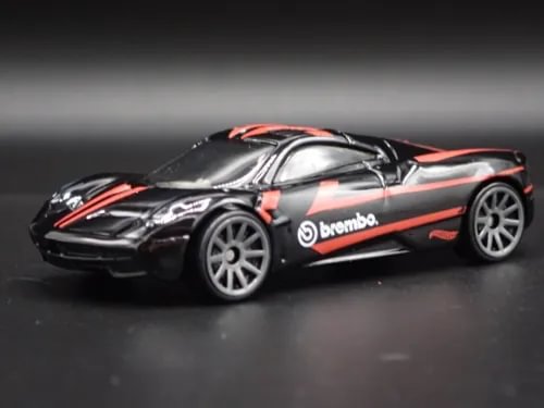 Diecast model car with orange racing stripes and brembo logo, silver-gray wheels