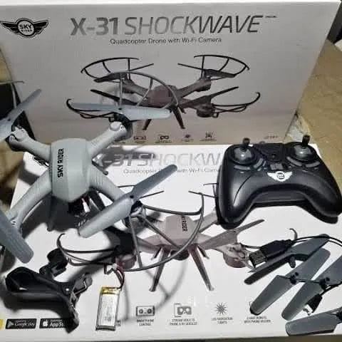 Silver and black quadcopter drone with handheld remote control and four propellers