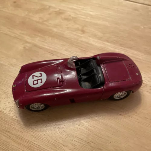 Maroon vintage race diecast model car with open cockpit and front hood details