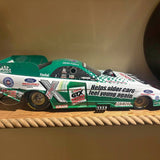 Green and white John Force diecast race car with sponsor decals, front view