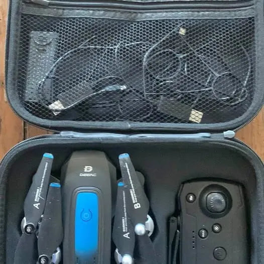 Drone and remote controller in open hard case with blue status light