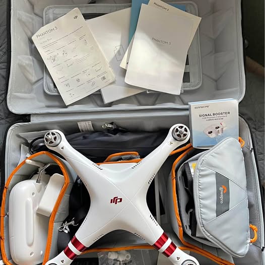 DJI Phantom 3 drone with white body, orange accents, and propellers in a backpack