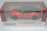 Kinsmart die-cast toy car in display box, orange sports coupe, front view