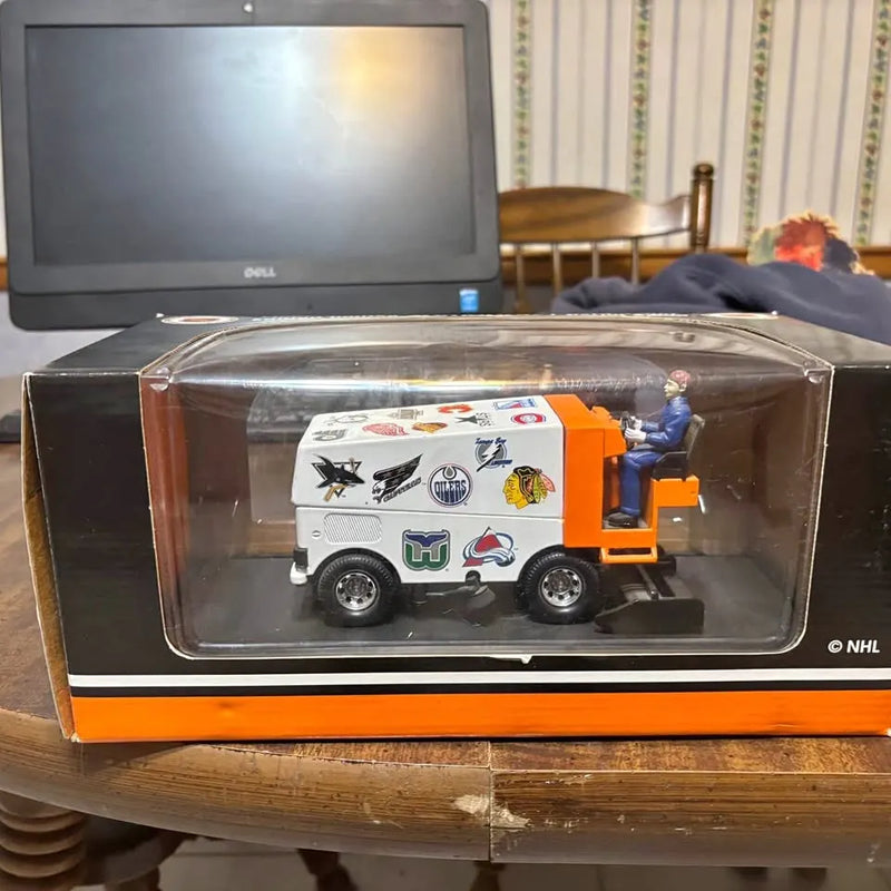 Diecast ice-resurfacing Zamboni toy vehicle in clear display case with orange base