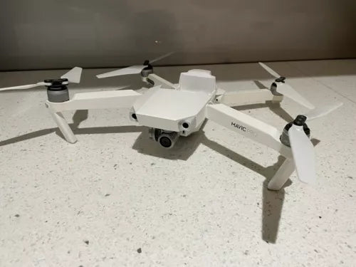 White DJI quadcopter drone with camera gimbal and four propellers