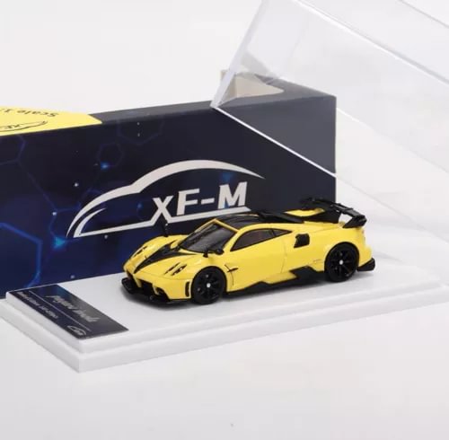 Yellow 1/64 diecast model car on white display base in open box