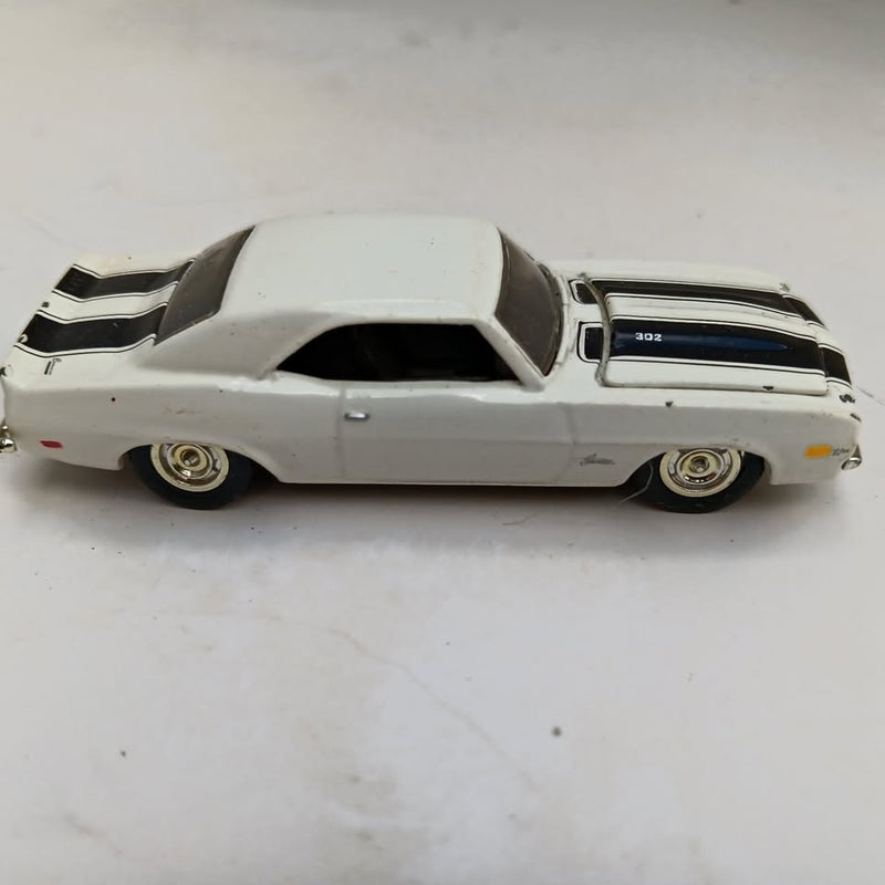 White diecast 1969 Camaro coupe with black racing stripes, side view