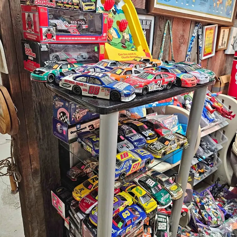 Diecast NASCAR race cars with colorful sponsor graphics on display rack