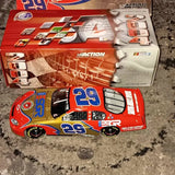 Red diecast race car with number 29 and blue/yellow side graphics, in packaging