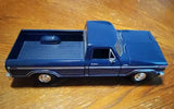 Blue diecast Ford F-150 pickup truck with black side stripes