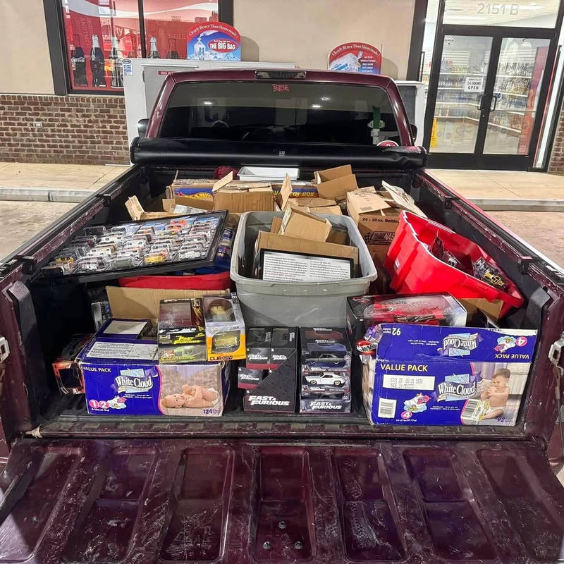 Boxed diecast toy cars and accessories in an open truck bed display tray