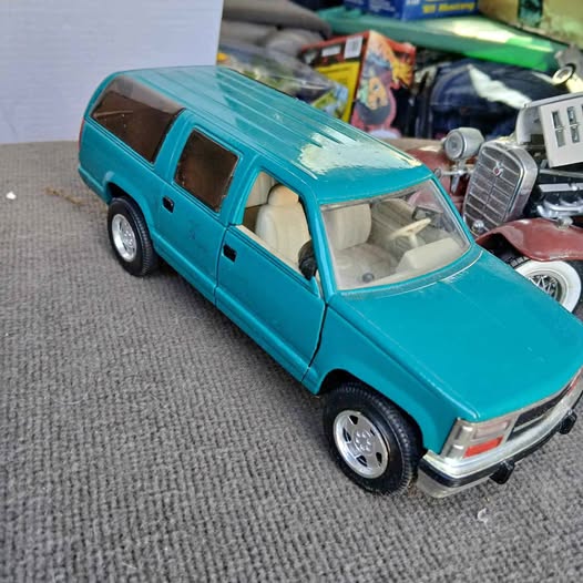 Turquoise diecast pickup truck with black wheels and detailed headlights