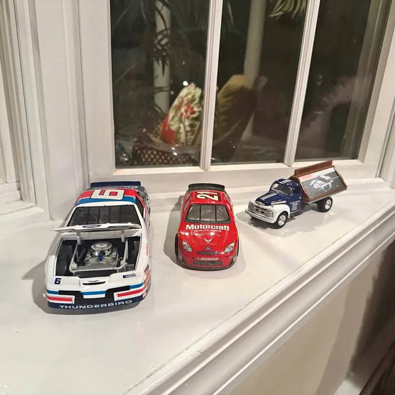 Diecast model car set with three cars: white, red, and blue pickup on display