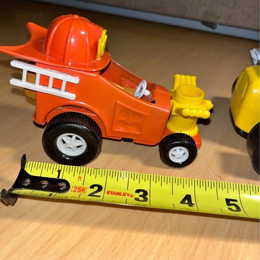 Vintage orange diecast fire truck toy with ladder and wheels