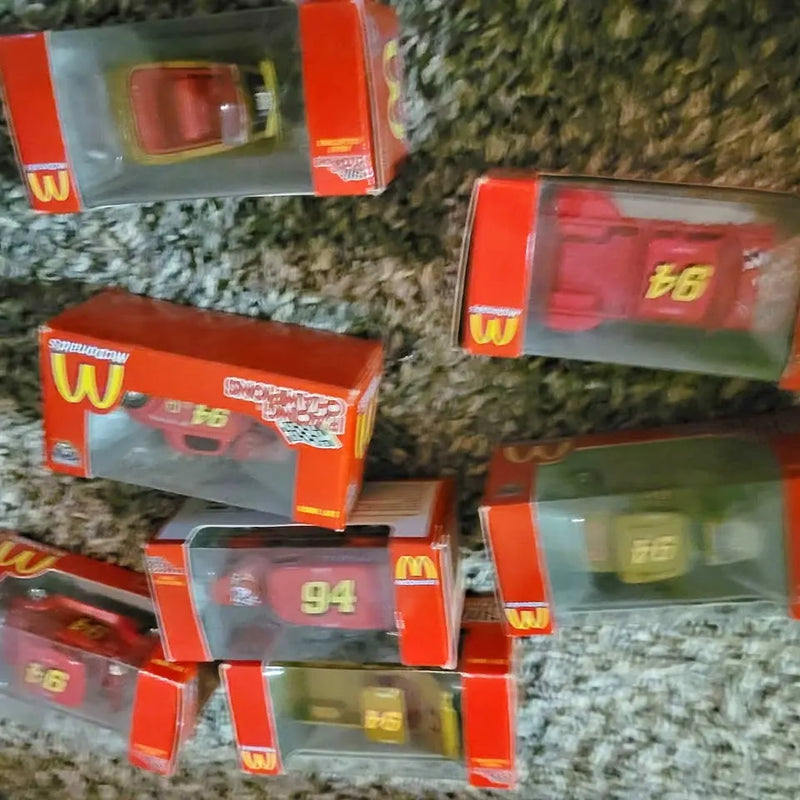 Diecast toy vehicles in orange-and-clear boxes with visible numbers 66, 94