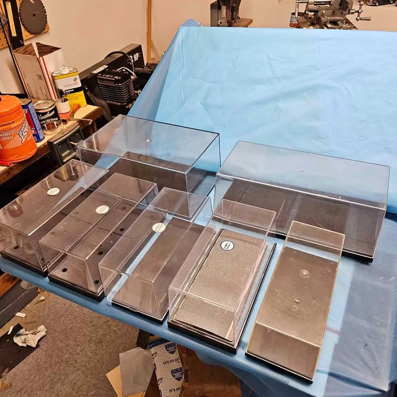 Diecast car display case with clear compartments and hinged lids on blue base