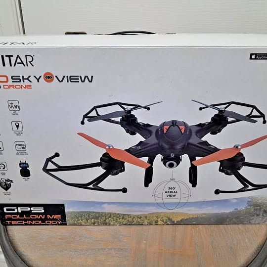 Orange quadcopter drone with front camera and four prop arms