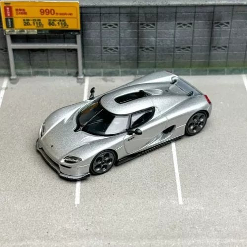 Silver sports car diecast model with black hood vents and dark wheels, 3/4 view