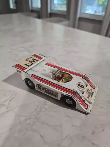 Diecast race car model toy, white with red stripes and sponsor decals, front-left view