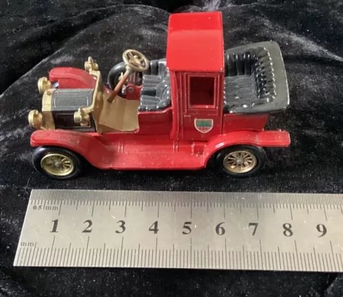 Red vintage die-cast car model, side view with open engine detail and raised hood
