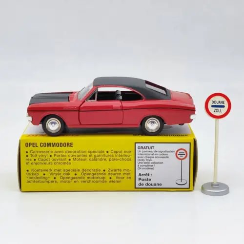 Red diecast model car with white wheels, on original retail box