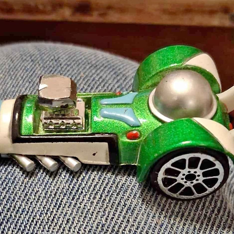 Green and white diecast racer car with silver dome front and detailed side panel