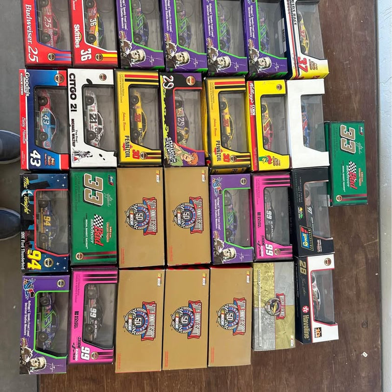 Assorted NASCAR diecast cars in colorful retail boxes, multiple designs and numbers
